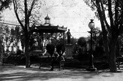 Hombre sentado en la banca de una plaza pública