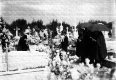 Grupo de personas durante una ceremonia funebre en un panteón