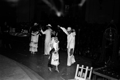 Bailarines efectunado una danza regional en un salón de sorteos de la Lotería Nacional