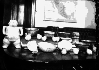 Figuras antropomorfas y vasijas prehispánicas sobre una mesa