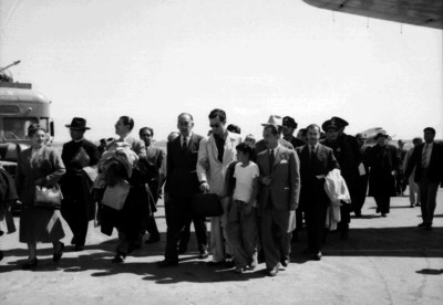 Carlos Arruza, pasajeros y otras personas caminan en el aeropuerto