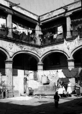Patio de una vecindad de dos pisos con portales