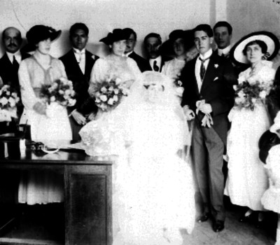 Pareja de novios acomapañados de familiares y amigos en una oficina durante el matrimonio civil, retrato de grupo