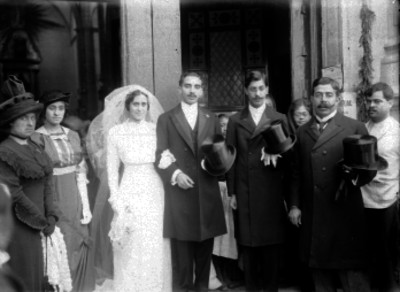 Pareja de novios acompañados de familiares y amigos en la entrada a un templo, retrato de grupo