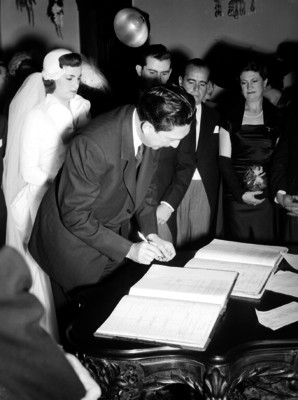Miguel Alemán Valdés firmando como testigo el acta del matrimonio civil de Amelia Casas Bernard y mauricio Urdaneta, en un salón