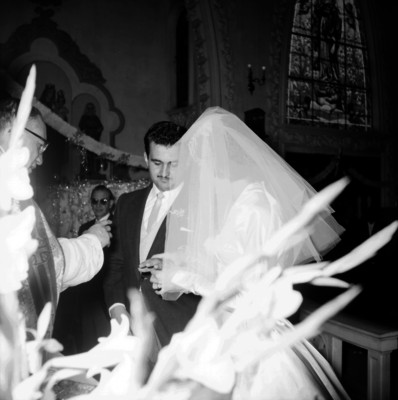 Novia colocando la argolla matrimonial al novio, durante la ceremonia religiosa