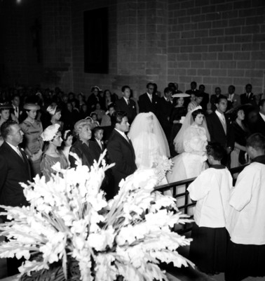 Novios y familares frente al sacerdote durante su boda