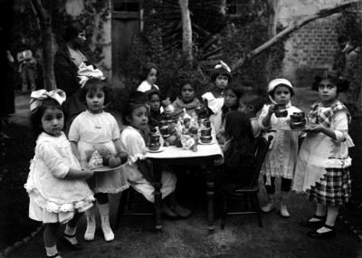 Niñas comiendo en un jardín de una escuela, durante una representación teatral en un festival