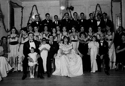 Quinceañera acompañada por familiares, damas y chambelanes, retrato de grupo