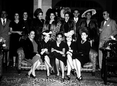 Hombres y mujeres en la sala de una casa durante un evento social, retrato de grupo