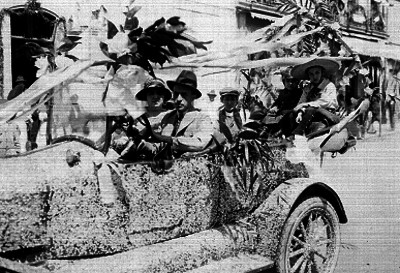 Pareja con niños en un carro durante un carnaval