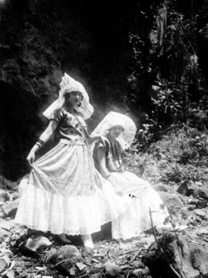 Mujeres vestidas con trajes típicos en un jardín, retrato