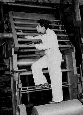 Empleados limpiando los rodillos de una rotativa