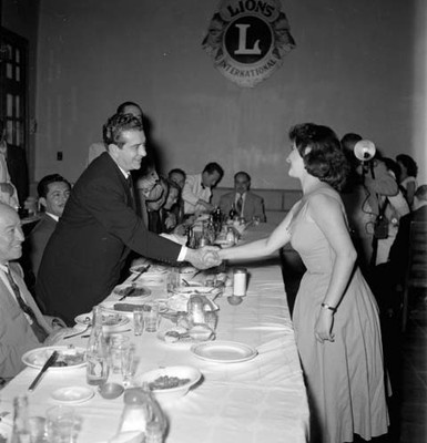 Adolfo López Mateos saludando a una mujer durante un banquete
