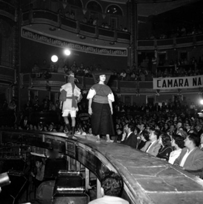 Pareja modelando trajes regionales en el homenaje a Adolfo López Mateos en el Teatro Iris