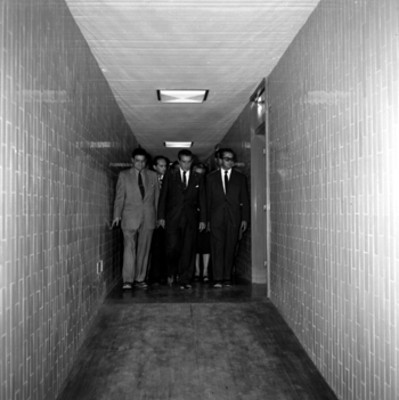 Adolfo López Mateos, Ernesto Uruchurtu y demás funcionarios en el corredor de un edificio durante su gira por el D.F.