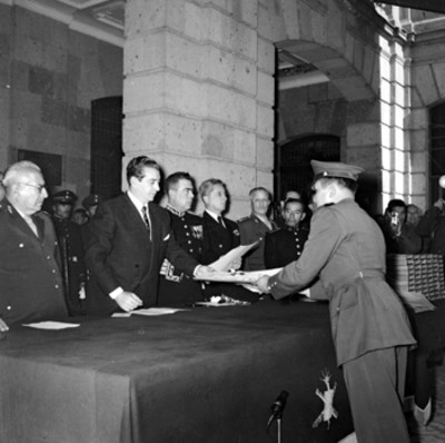 Adolfo López Mateos entregando documento a miembro del colegio militar durante inauguración de cursos