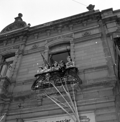 Partidarios del PRI en el balcón de un edificio, durante la bienvenida a Adolfo López Mateos a Puebla
