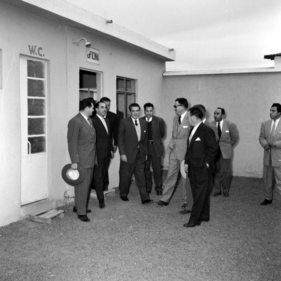 Adolfo López Mateos y ganaderos recorriendo cobertizos durante su visita en campaña al centro de inseminación artificial en Tulancingo