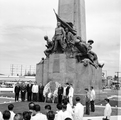 Adolfo López Mateos con Manuel J. Tello y funcionarios públicos montan guardia al monumento al escuadrón 201 durante una ceremonia