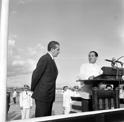 Adolfo López Mateos y su esposa escuchando palabras de bienvenida del presidente Diosdado Macapagal en el aeropuerto de Filipinas