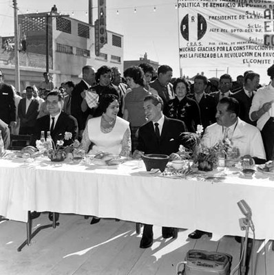 Adolfo López Mateos con Ernesto Uruchurtu P. durante comida organizada por vendedores, en una calle