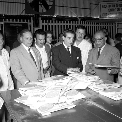 Adolfo López Mateos con políticos del PRI observan envases para empacado de camarón en la Congeladora Madero durante su gira electoral