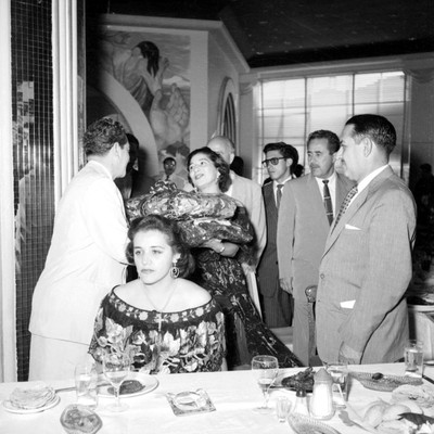Adolfo López Mateos recibiendo trajes típicos obsequiados por la señora de Aranda Osorio durante banquete a su campaña en el Hotel Bonampak en Tuxtla Gutiérrez
