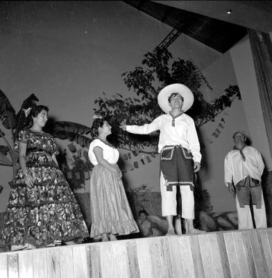 Hombres y mujeres con trajes típico en un festival en el Centro Social Francisco I. Madero