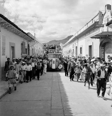 Adolfo López Mateos y comitiva abordo de una camioneta recorriendo San Cristóbal de las Casas, en su campaña electoral
