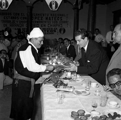 Adolfo López Mateos da autógrafo a un chamula, durante un banquete