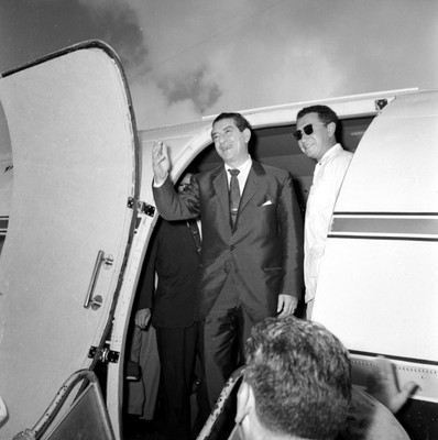 Adolfo López Mateos en compañía de otros individuos, descendiendo de un avión