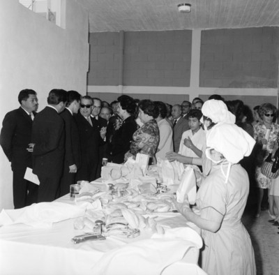 Eva Sámano, Herlinda Torres, Jaime Torres Bodet y funcionarios observando elaboración de desayunos escolares en la planta de Cuernavaca