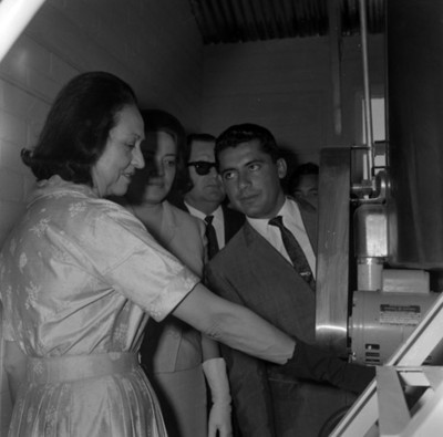 Eva Sámano observando una máquina durante su visita a unas instalaciones industriales