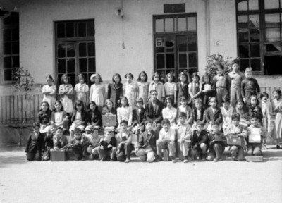 Maestra y alumnos en el patio de una escuela
