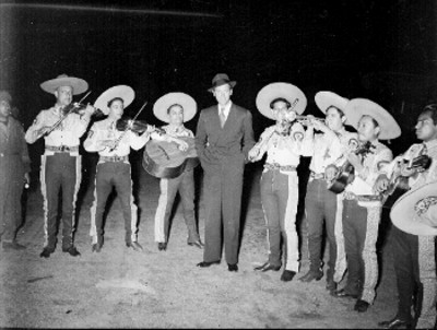 James Stewart entre mariachis que le dan la bienvenida cantando en el aeropuerto de la cd. de México