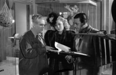 Director con pareja de actores leyendo libreto durante filmación de una película