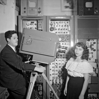 Camarógrafo filmando a una artista en un estudio de radio