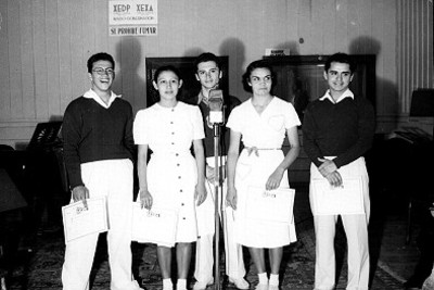 Hombres y mujeres con diplomas de la XERH ante micrófono de la radiodifusora XEDP XEXA radio Gobernación, retrato