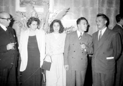 Publicistas y mujeres durante brindis en la exposición de automóviles de la Craysler