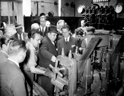 Ramón Beteta y funcionarios públicos observan la maquinaria para la acuñación de monedas