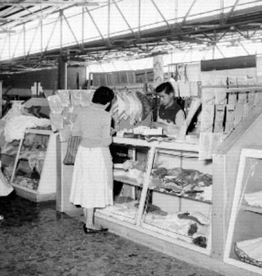 Mujer comprando en un puesto de ropa del mercado de Jamaica