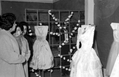 Margarita García Flores observando vestidos en exposición durante su visita a la Casa Núm. 5 del Seguro Social
