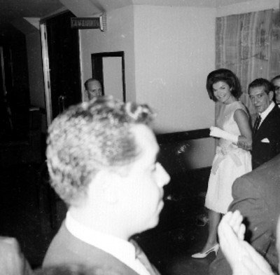 Adolfo López Mateos del brazo de Jacqueline Kennedy dirigiendose a un guardarropa