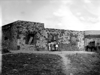 Familia frente a una construcción de piedra