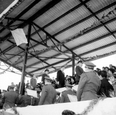 Agustín Olachea Avilés, Benito Coquet y Antonio Ortiz Mena caminan por un palco entre el público durante una ceremonia