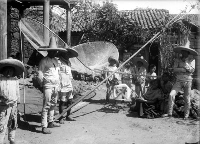 Indígenas purépechaS con redes para pesca en el patio de una casa