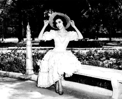 Elsa Cárdenas sentada en la banca de un jardín público, retrato