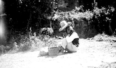 Mendigo con sombrero descansa en el campo