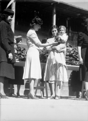 Mujer entrega una caridad a madre humilde, retrato